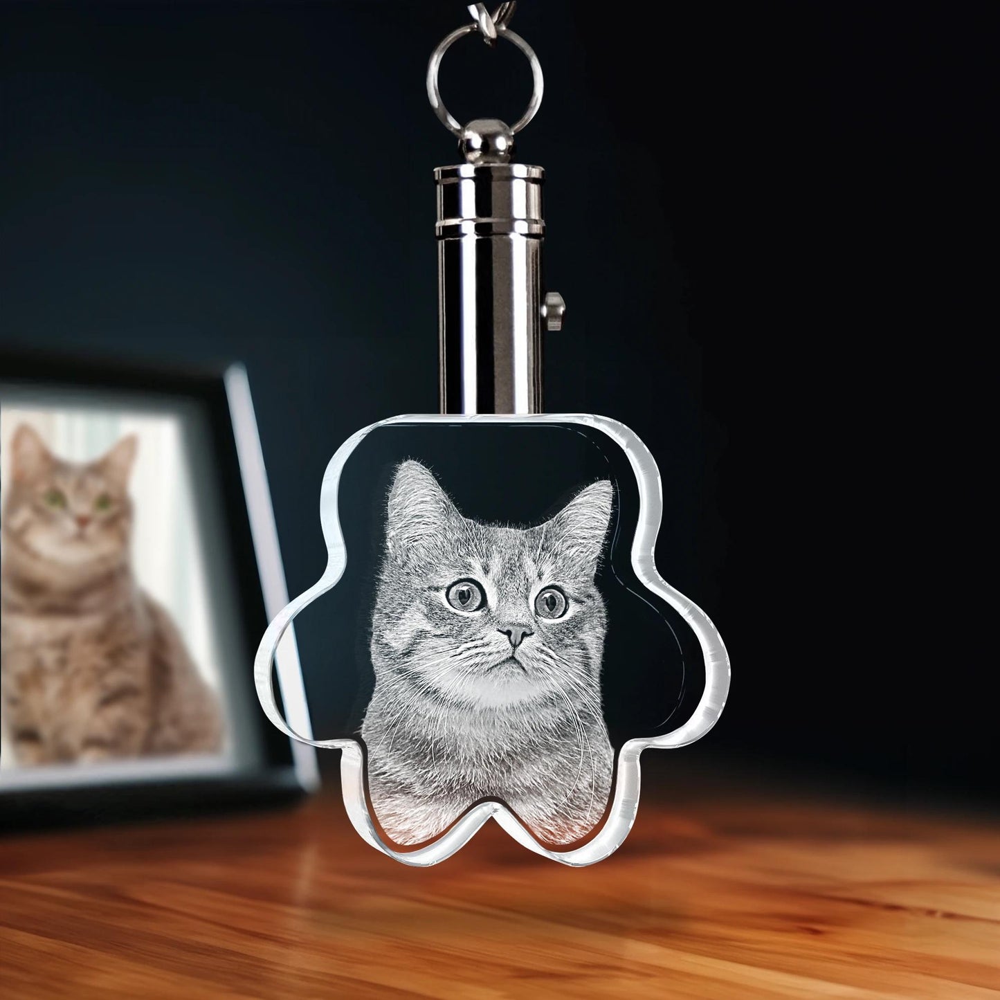 Keychain with a cat's face design on a wooden surface with a blurred background