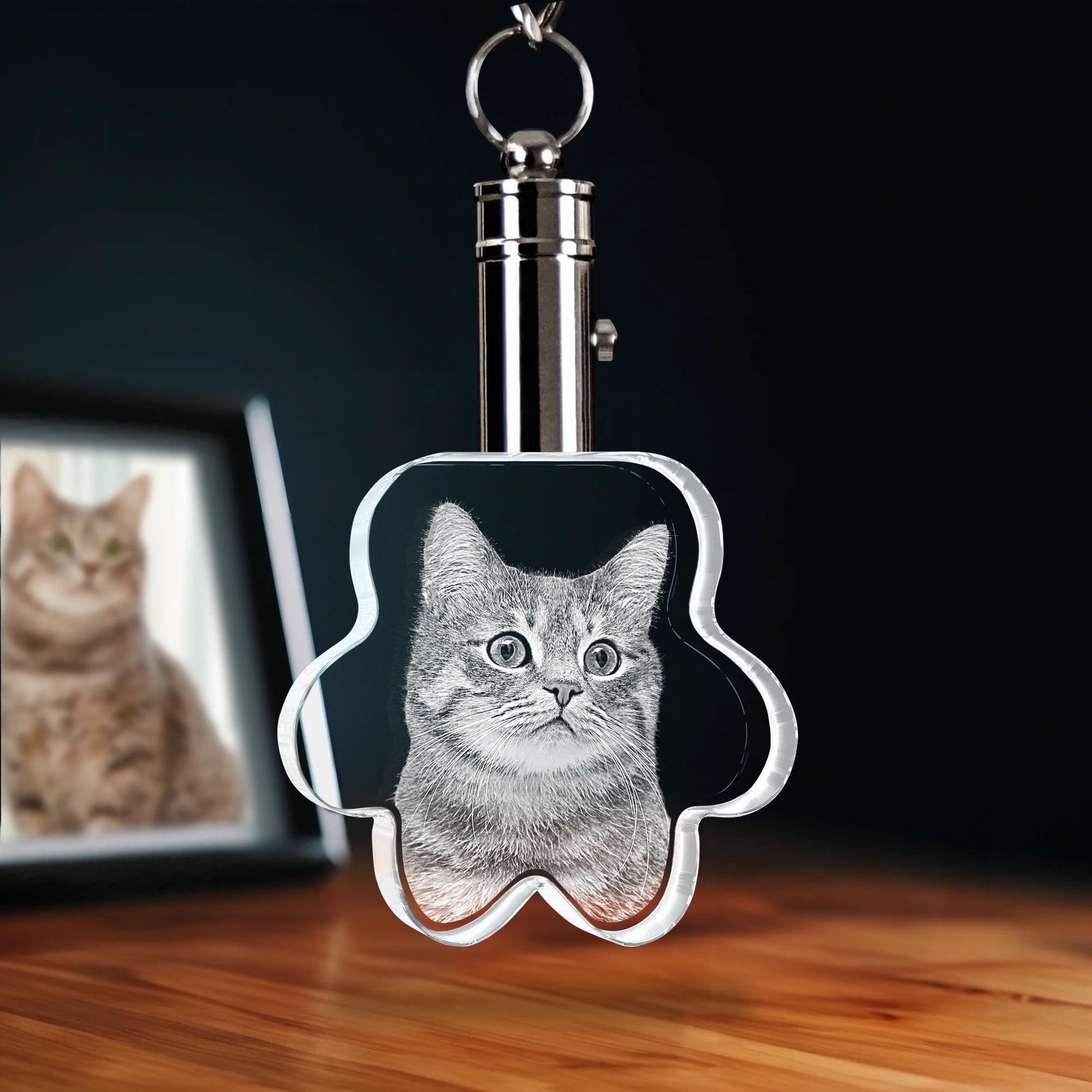 Keychain with a cat's face design on a wooden surface with a blurred background