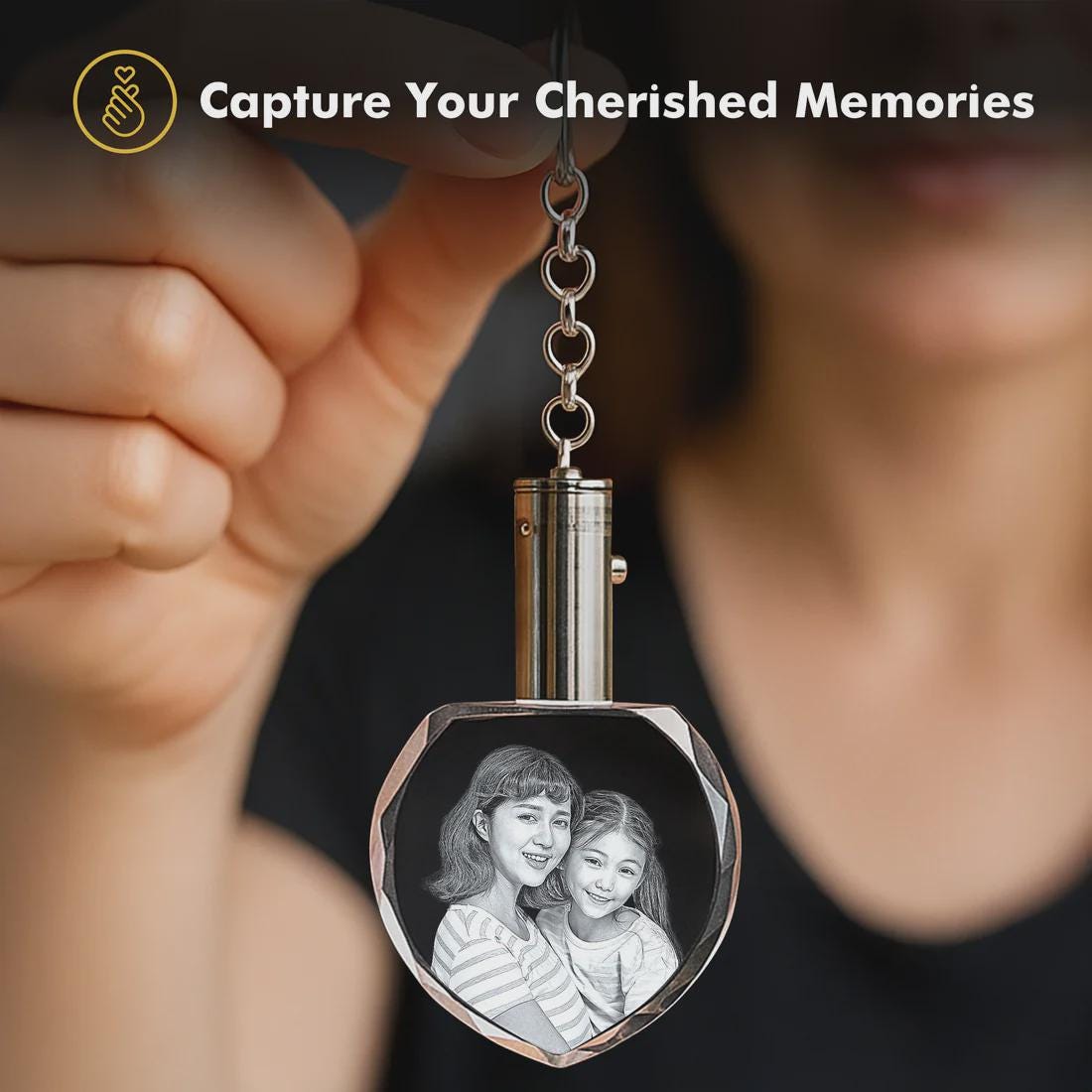 Heart-shaped photo keychain with a photo of two women, held by a hand with a blurred background.